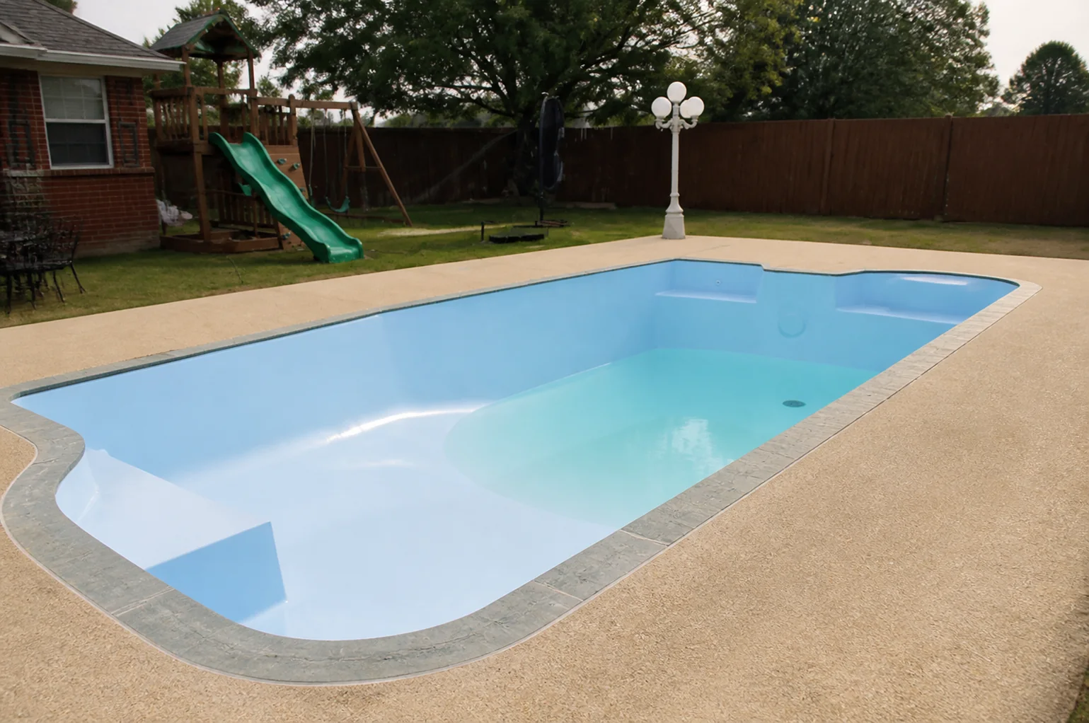 A clean, newly resurfaced light-blue pool ready for final fill